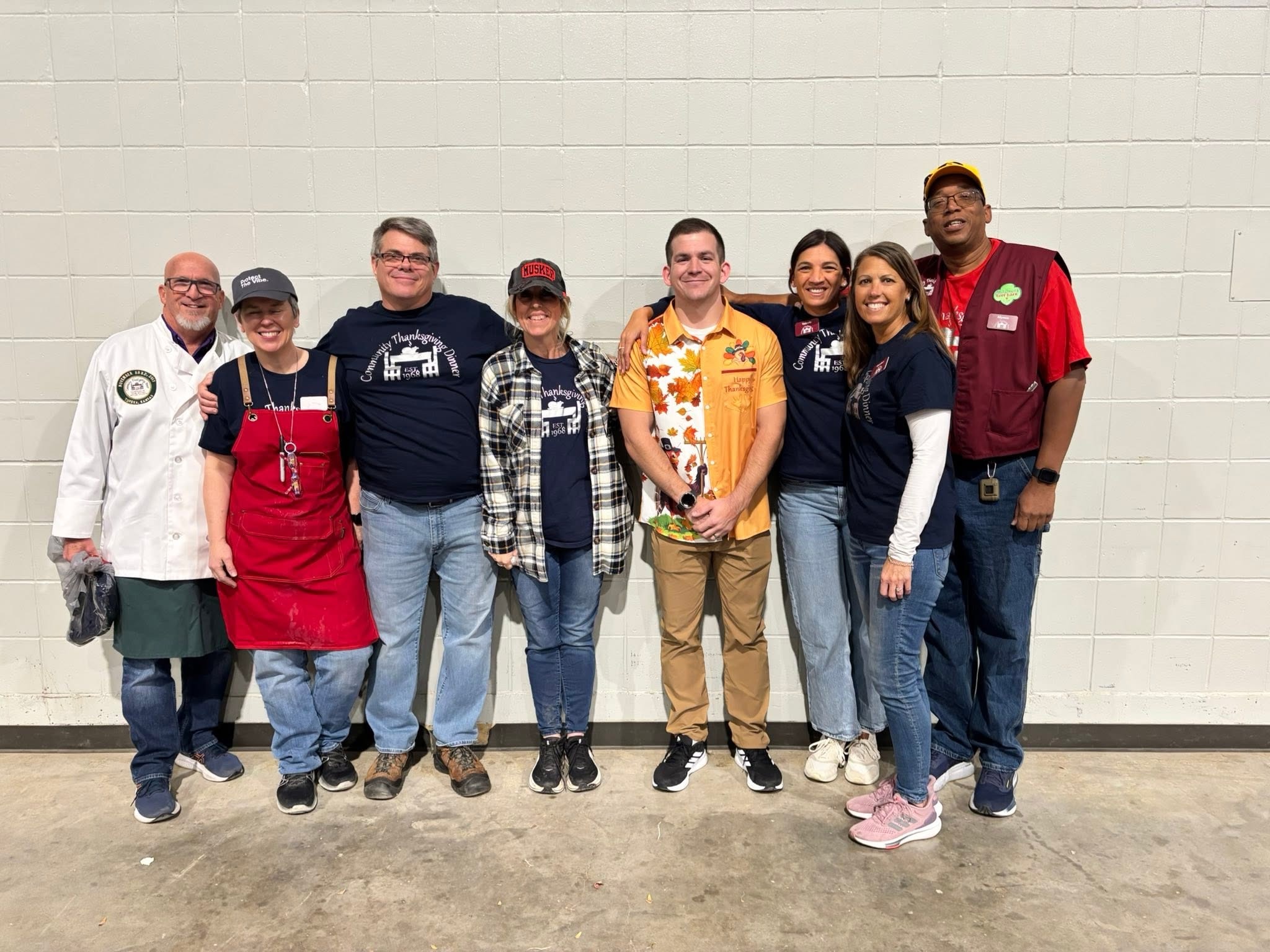 Eight Community Thanksgiving Dinner board members standing together.