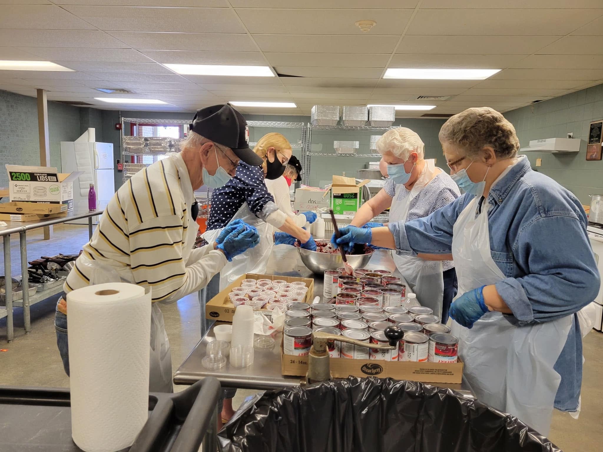 Volunteers working together to prepare food in the kitchen.